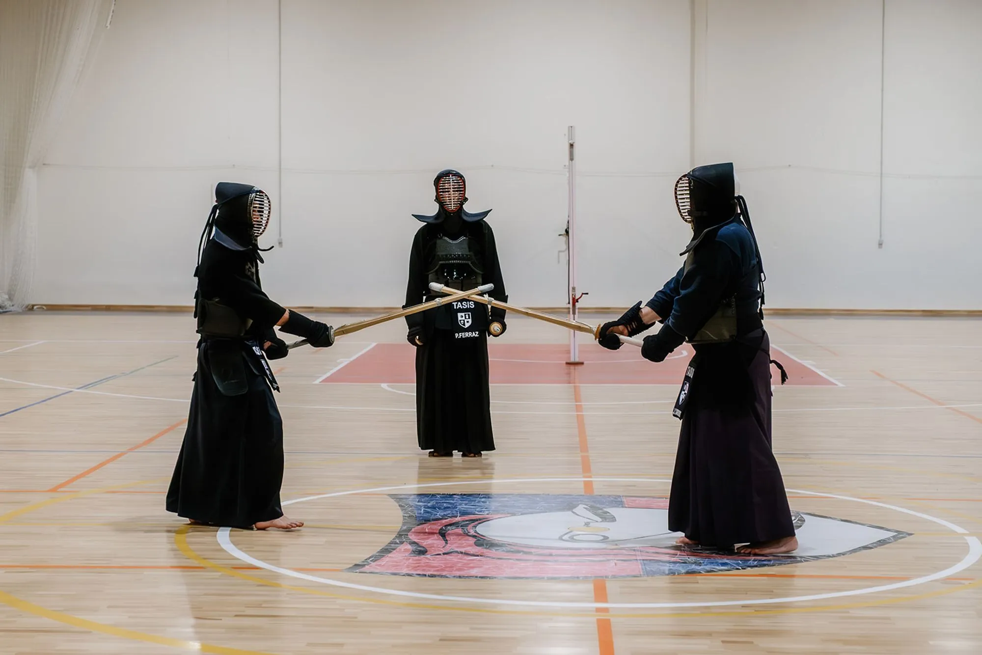 Three kendoka standing in line with shinai extended